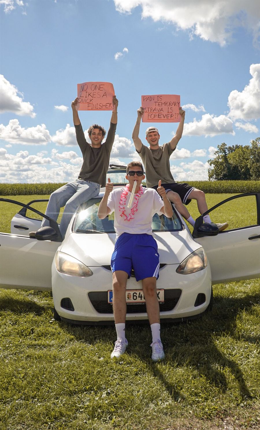 Fans mit Schildern auf dem Auto vor blauem Himmel