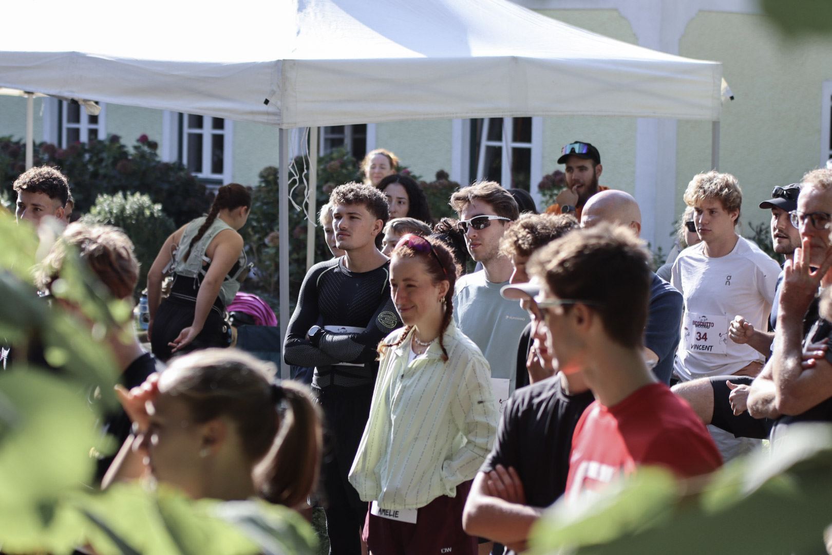 Läufer:innen versammeln sich vor dem Start im Camp mit den Zelten am Hof, 2026