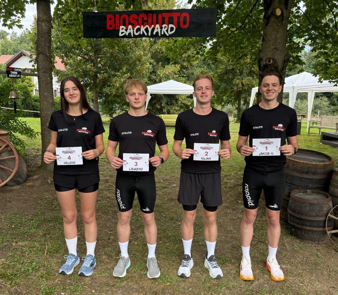 Jakob, Kilian, Laurenz und Helene mit Startnummern vor dem Biosciutto-Backyard-Torbogen
